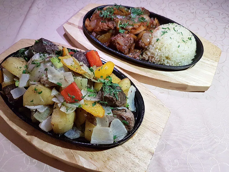 Два мясных блюда на чугунных сковородах с рисом